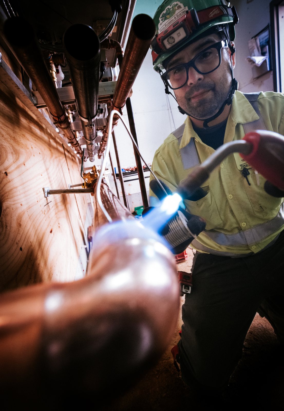 Tioga Plumbing plumber soldering a copper elbow with a torch in a Hurst, TX mechanical room