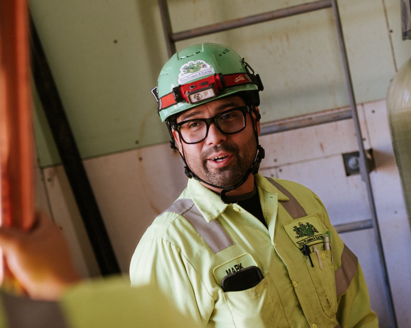 Tioga Plumbing plumber in a hard hat and headlamp during a commercial copper repipe in DFW