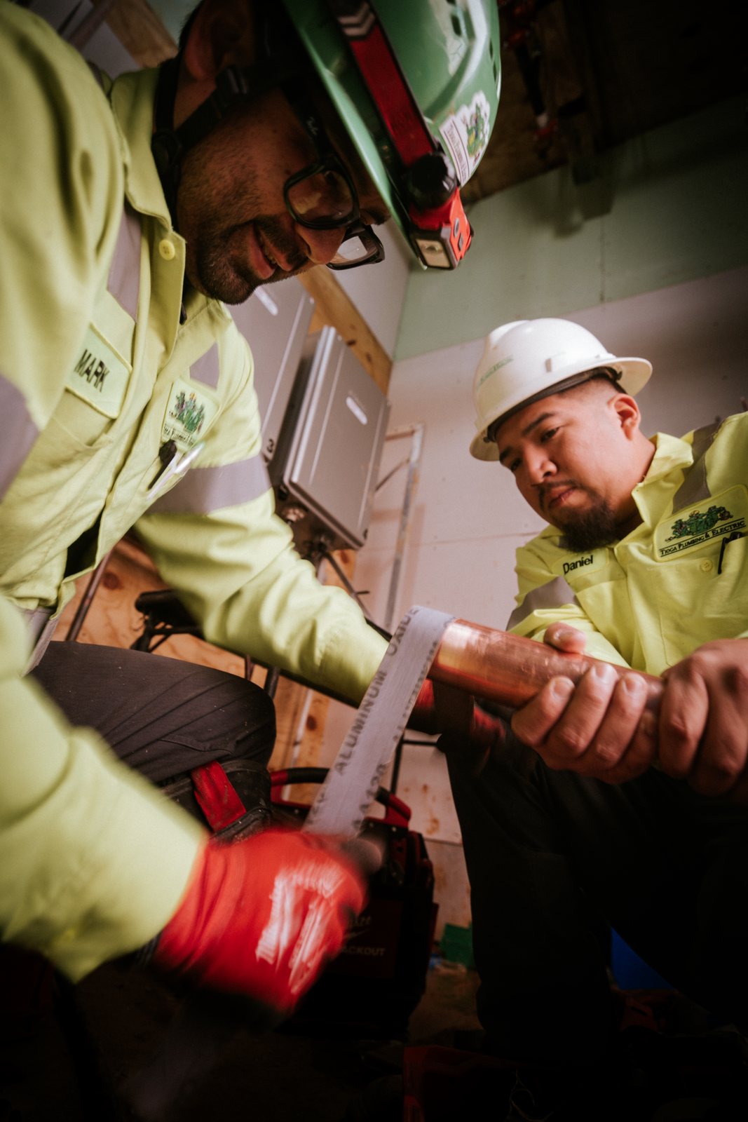 Two Tioga Plumbing technicians fitting copper pipe on a DFW commercial job
