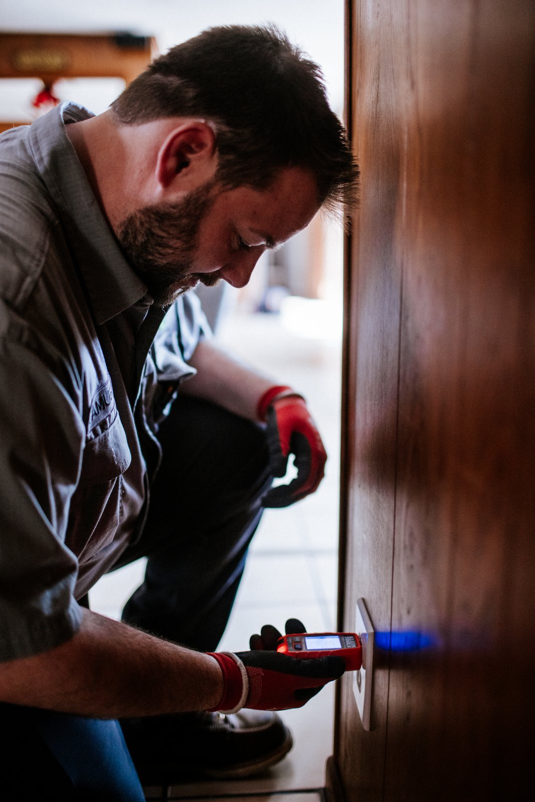 Tioga Plumbing technician checking a wall outlet with a tester during a DFW service call