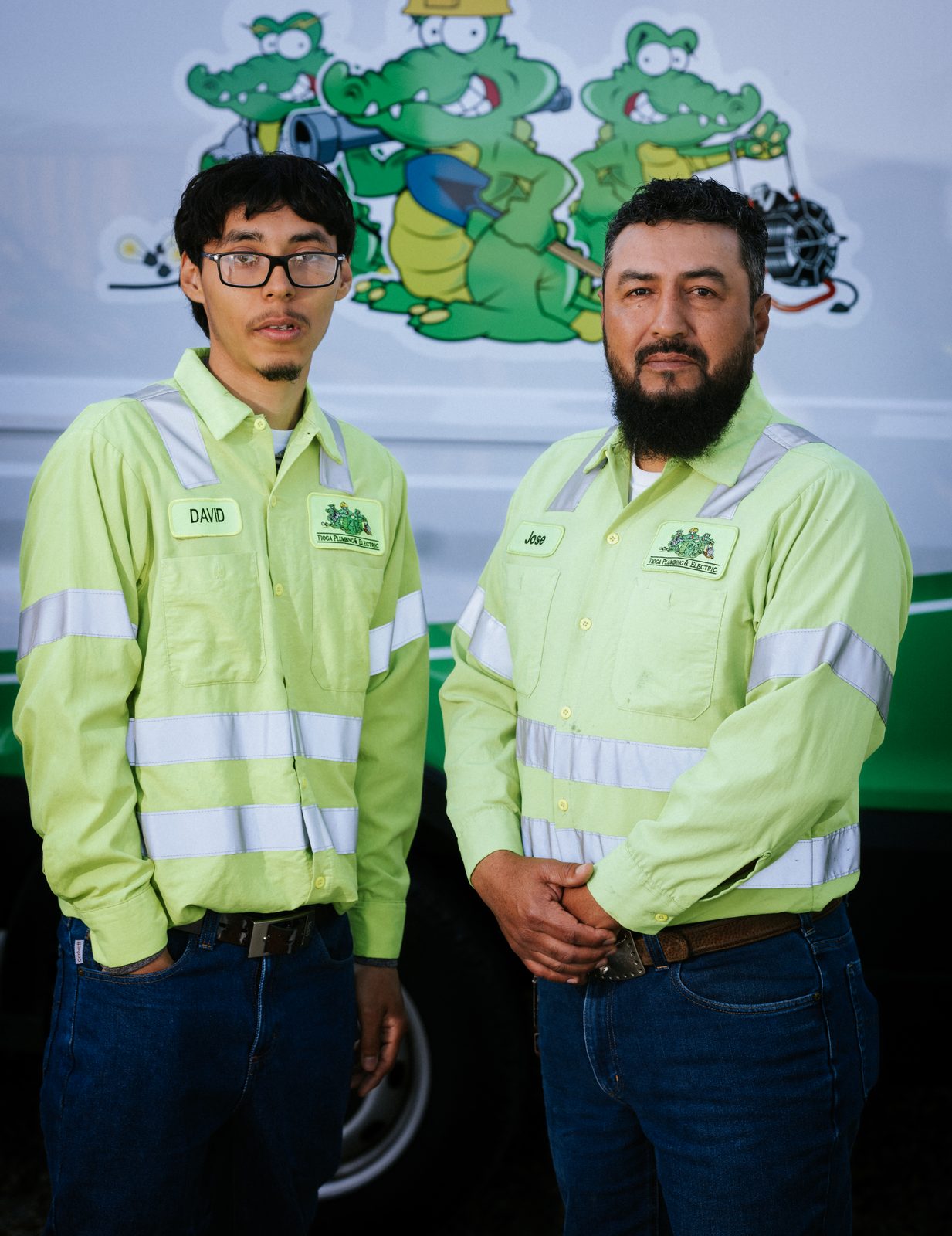 Two Tioga Plumbing technicians in front of the gator-wrapped service van