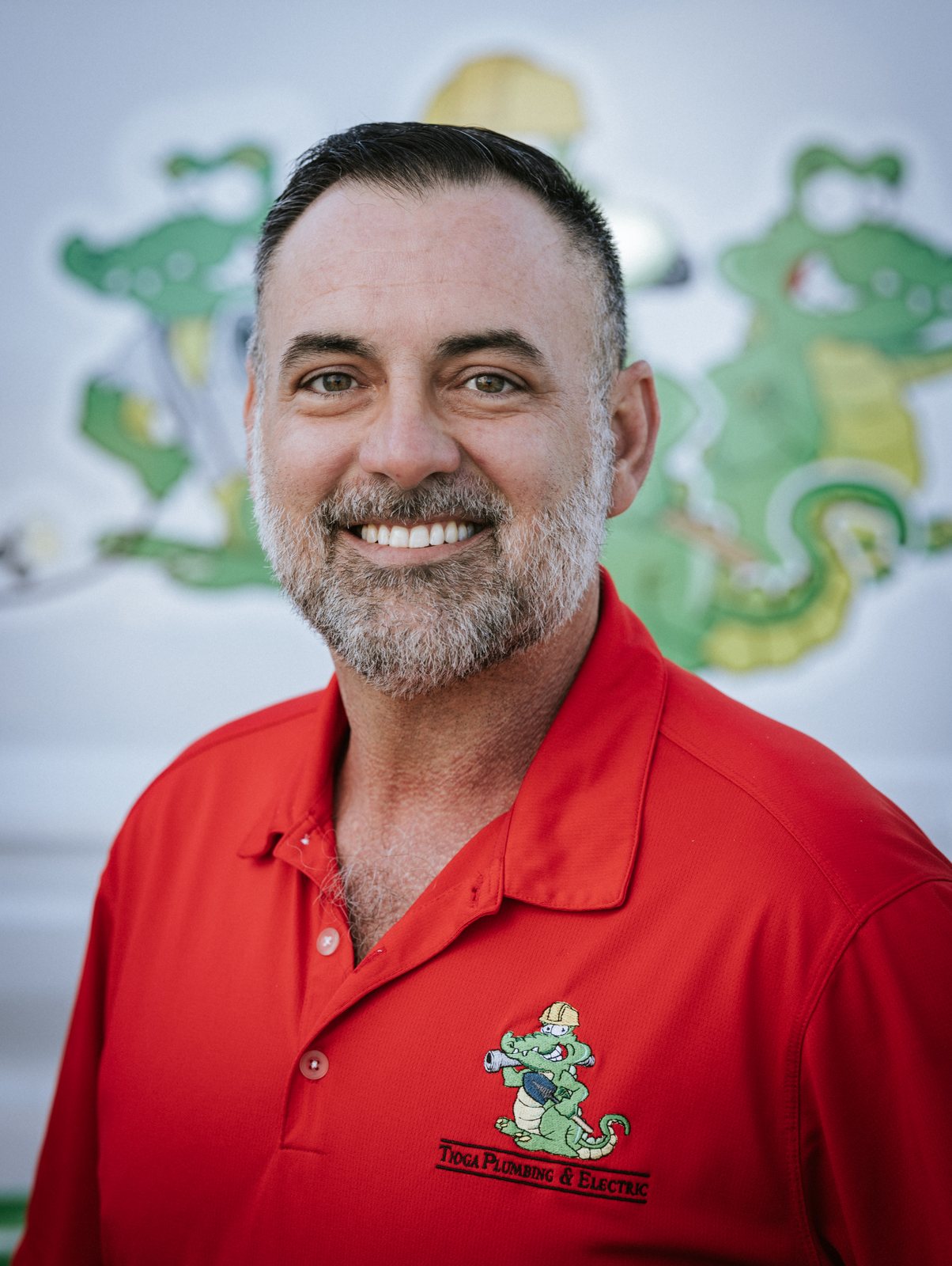 Tioga Plumbing team member portrait in front of the gator van
