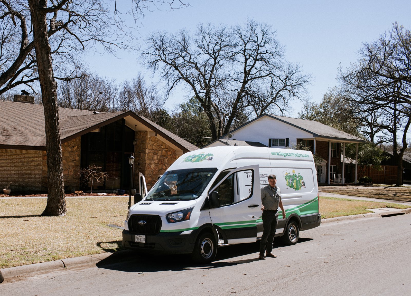 Tioga Plumbing service van parked at a customer's home in a DFW neighborhood