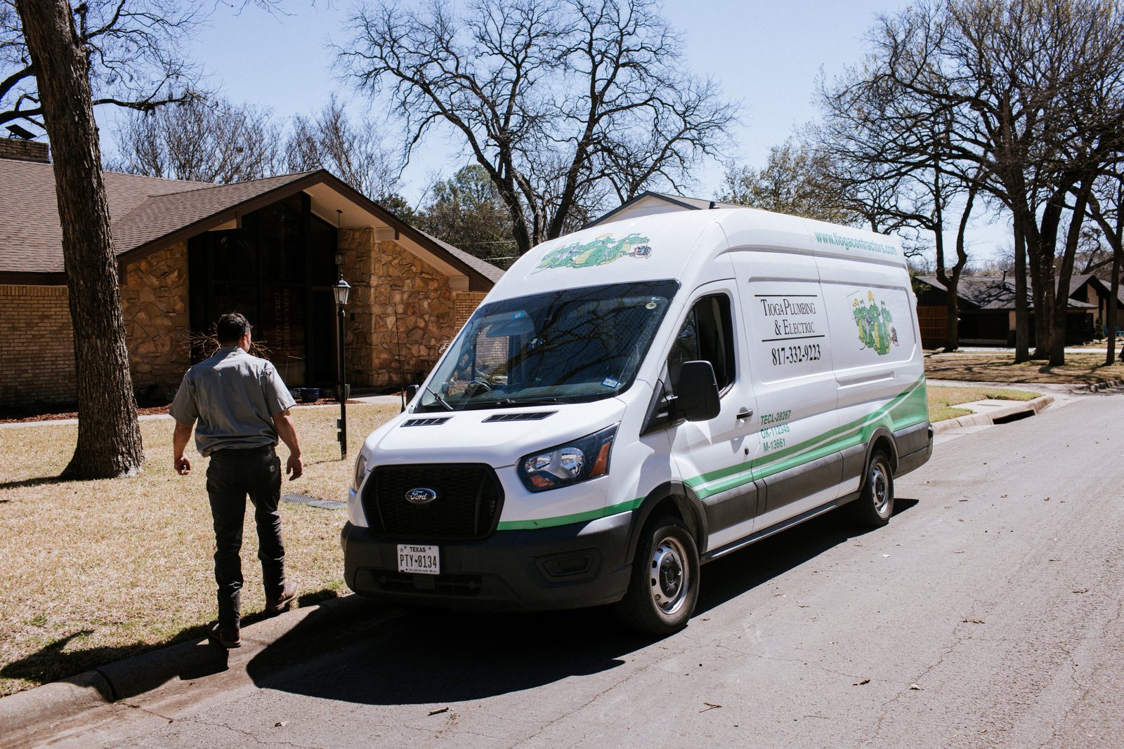 Tioga Plumbing plumber walking to a gator-wrapped van on a DFW street