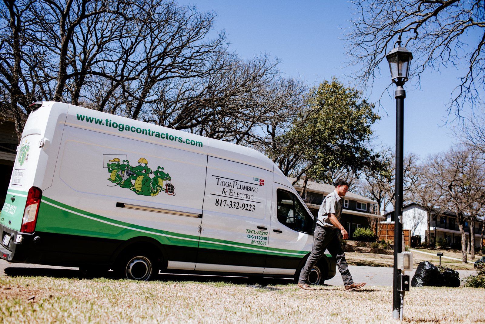 Tioga Plumbing van with the gator crew wrap at a DFW residential call