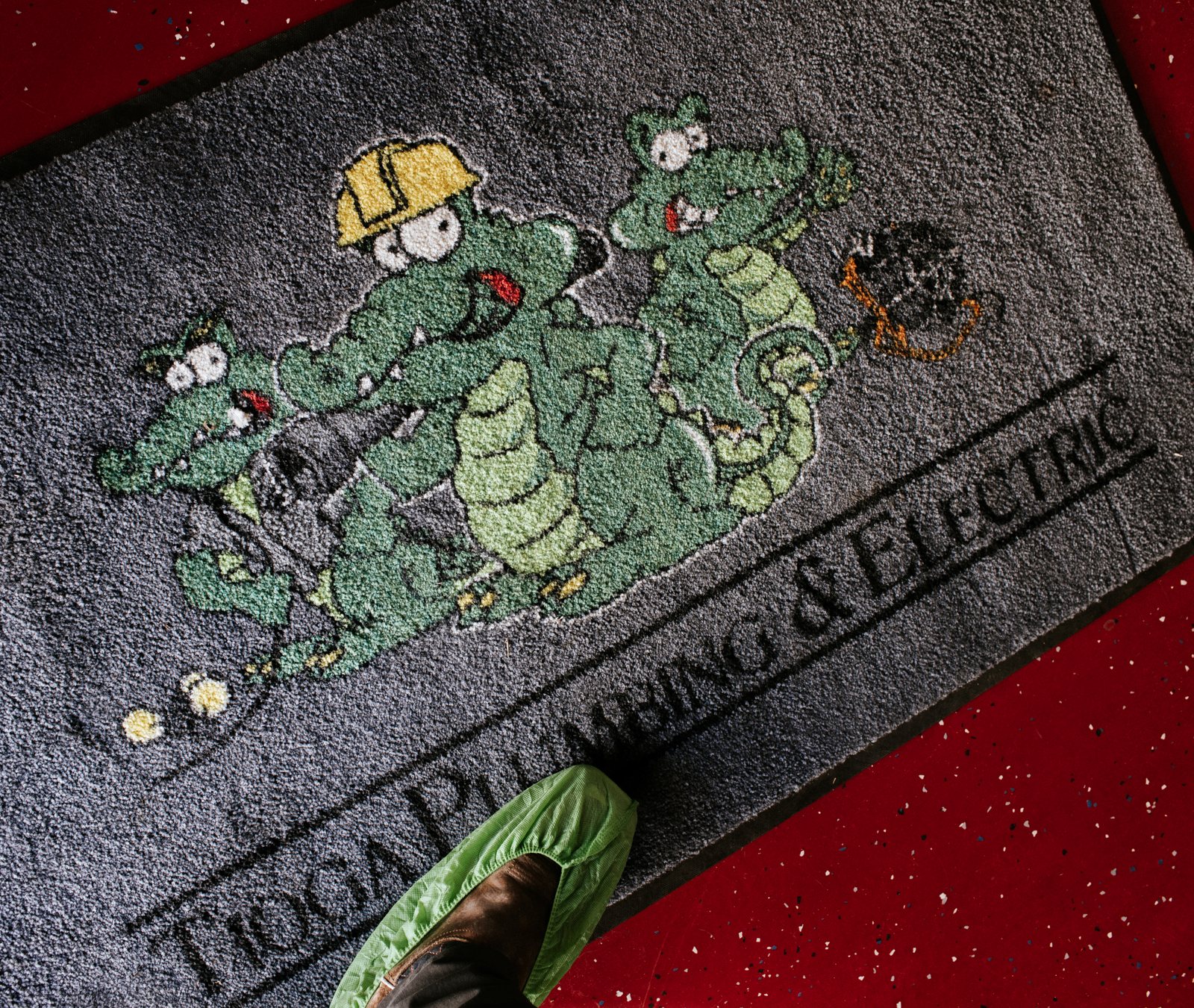 Tioga Plumbing gator doormat at a customer's front door