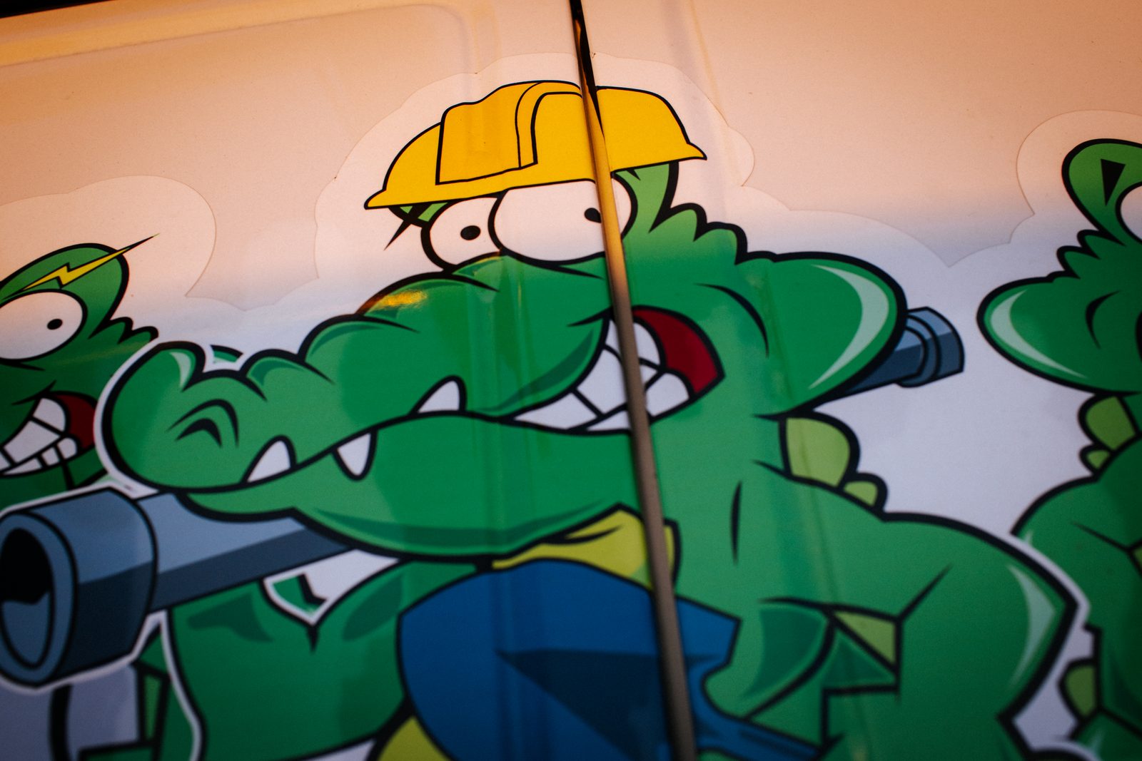 Close-up of the Tioga Plumbing gator mascot decal on a service van