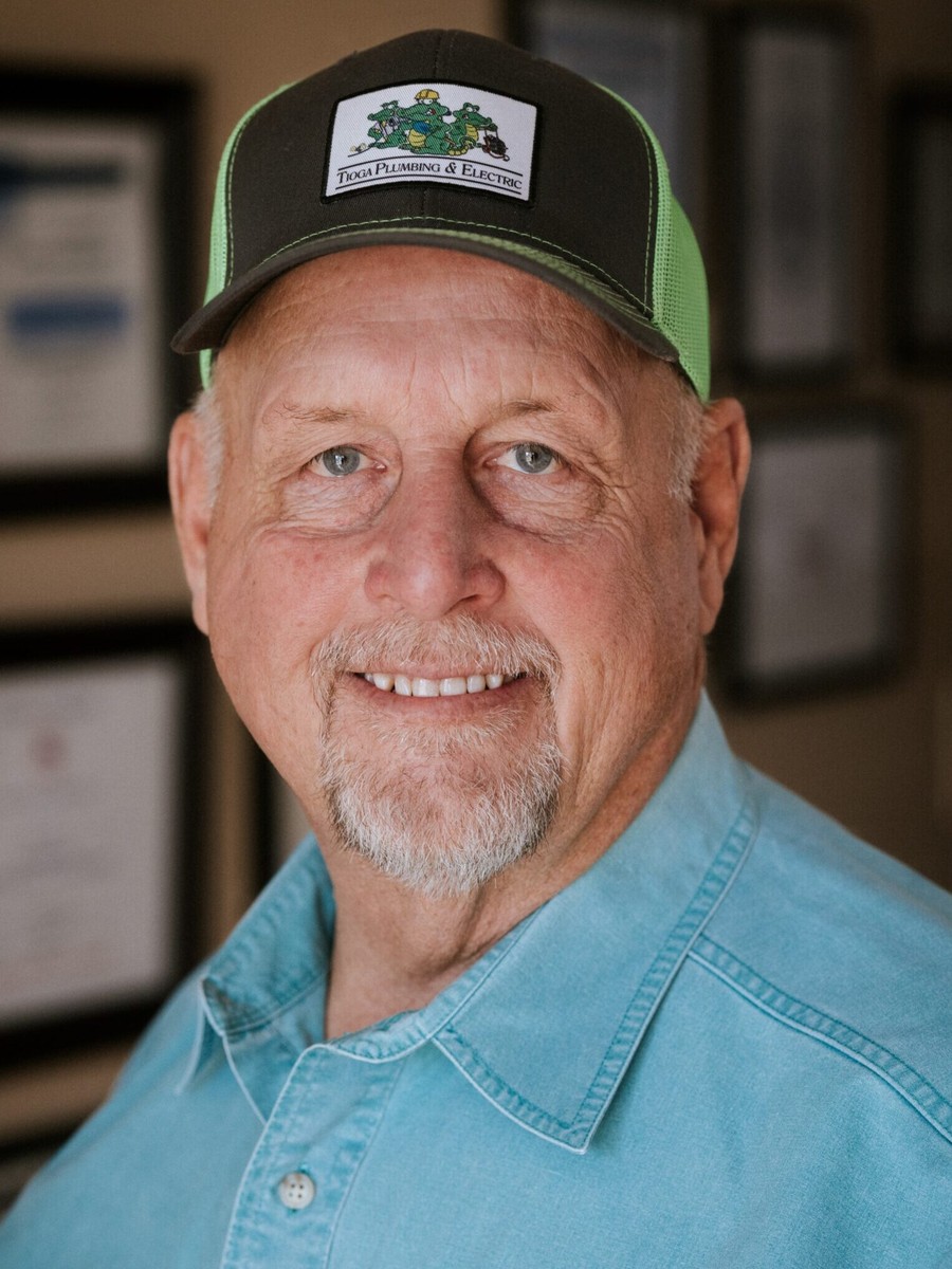 Jerry Carter, Co-Founder & COO of Tioga Plumbing and licensed Texas Master Plumber M-13661, photographed in front of the framed licenses at the Hurst, TX shop