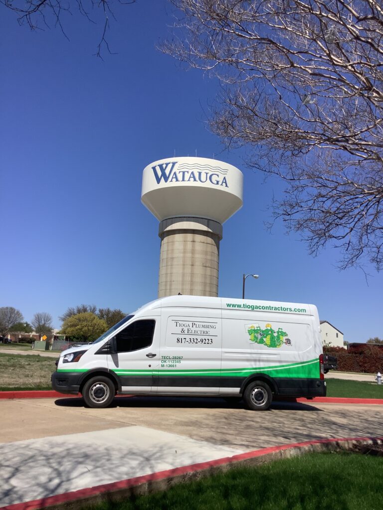 A Tioga Plumbing & Electric service van in front of one of the Watauga Texas water towers