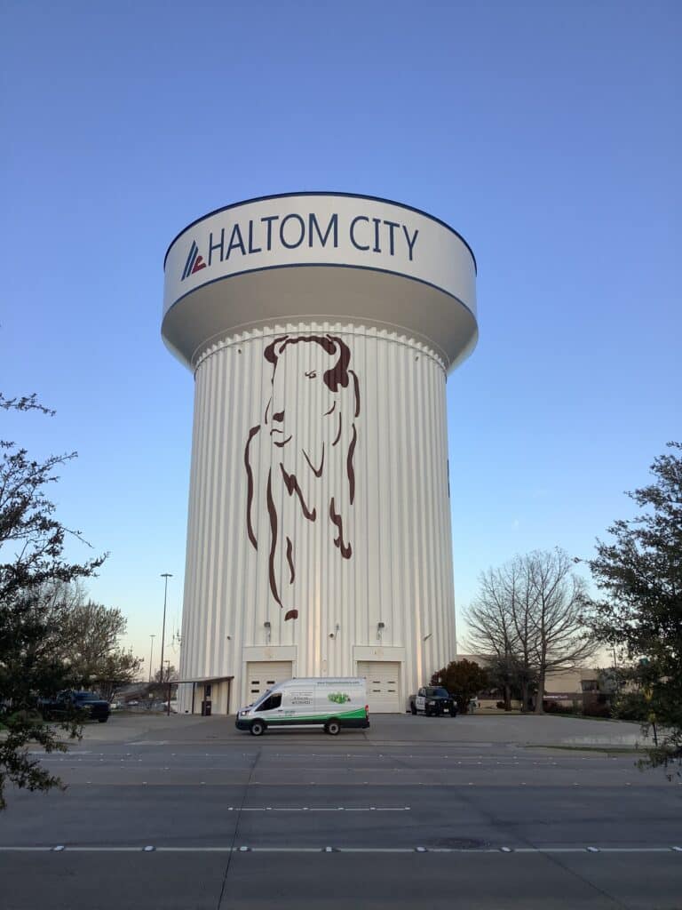One of the Tioga service vans in front of a Haltom City water tower in Haltom City Texas