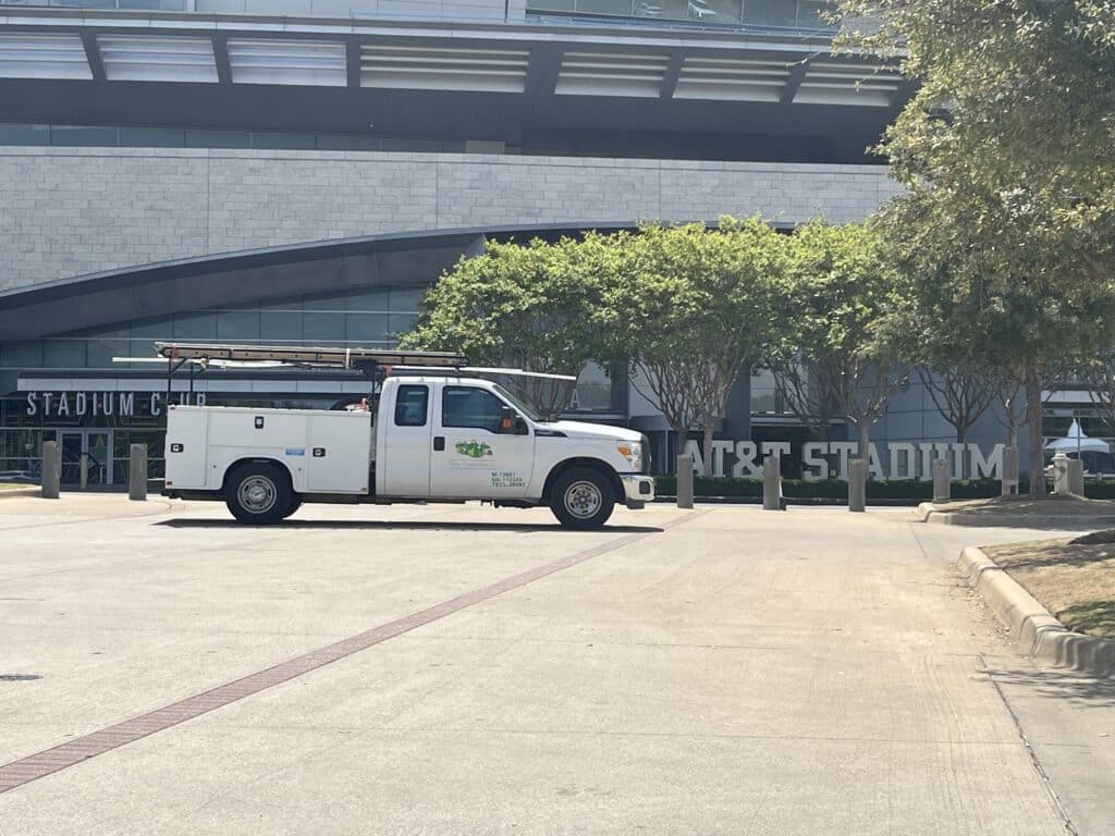 A Tioga Plumbing And Electric service truck in front of the AT&T stadium in Arlington Texas