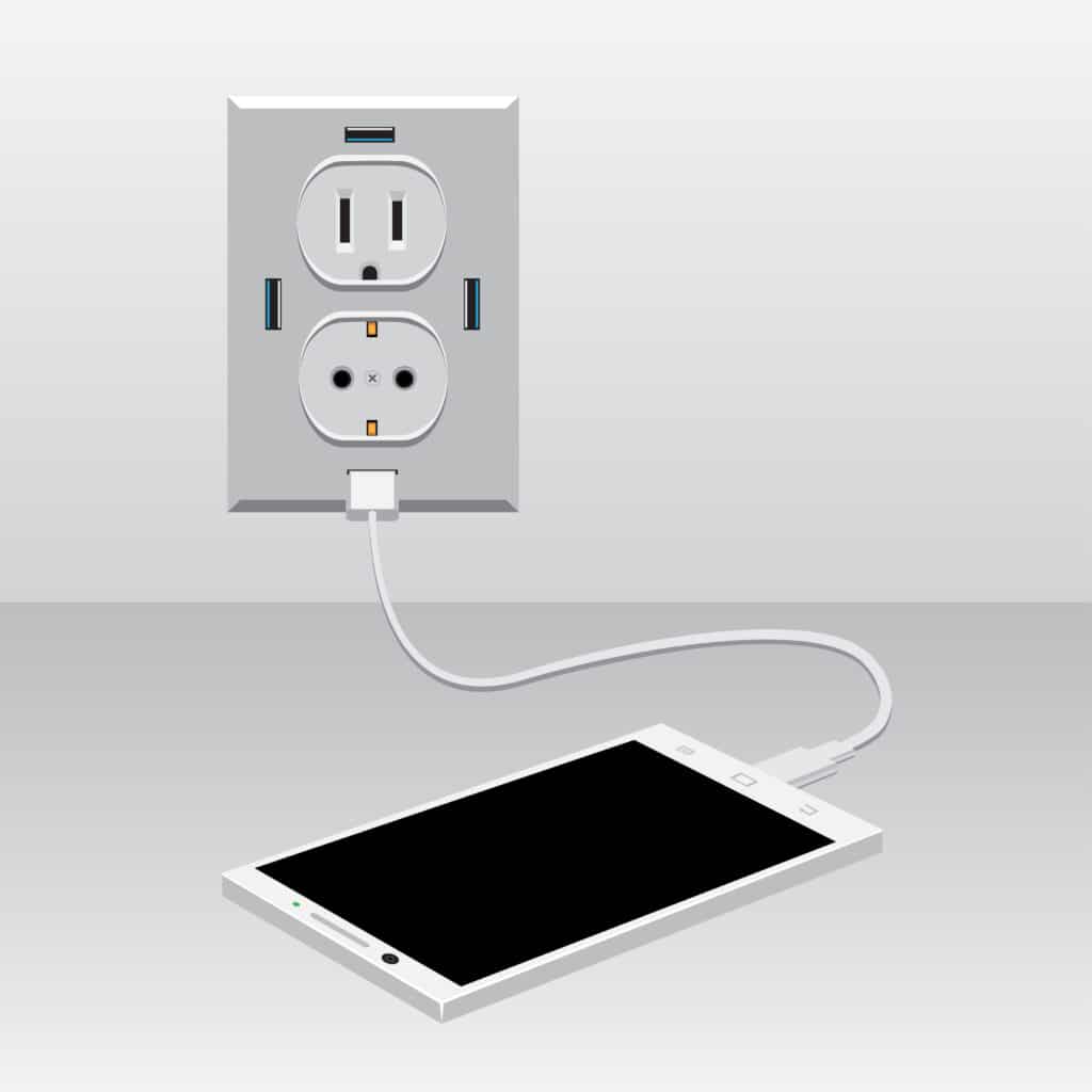 White smartphone charging from a USB outlets.